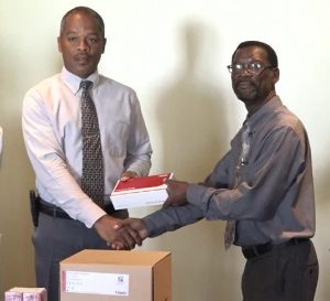 Senior Pastor and Island Coordinator of the Seventh Day Adventist Church Stanton Adams presents lab equipment to Hospital Administrator Gary Pemberton at a ceremony at the Alexandra Hospital on March 15, 2017